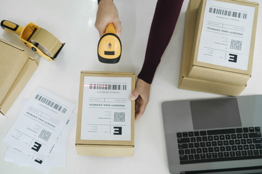 Female online business owner scan shipping label on parcel