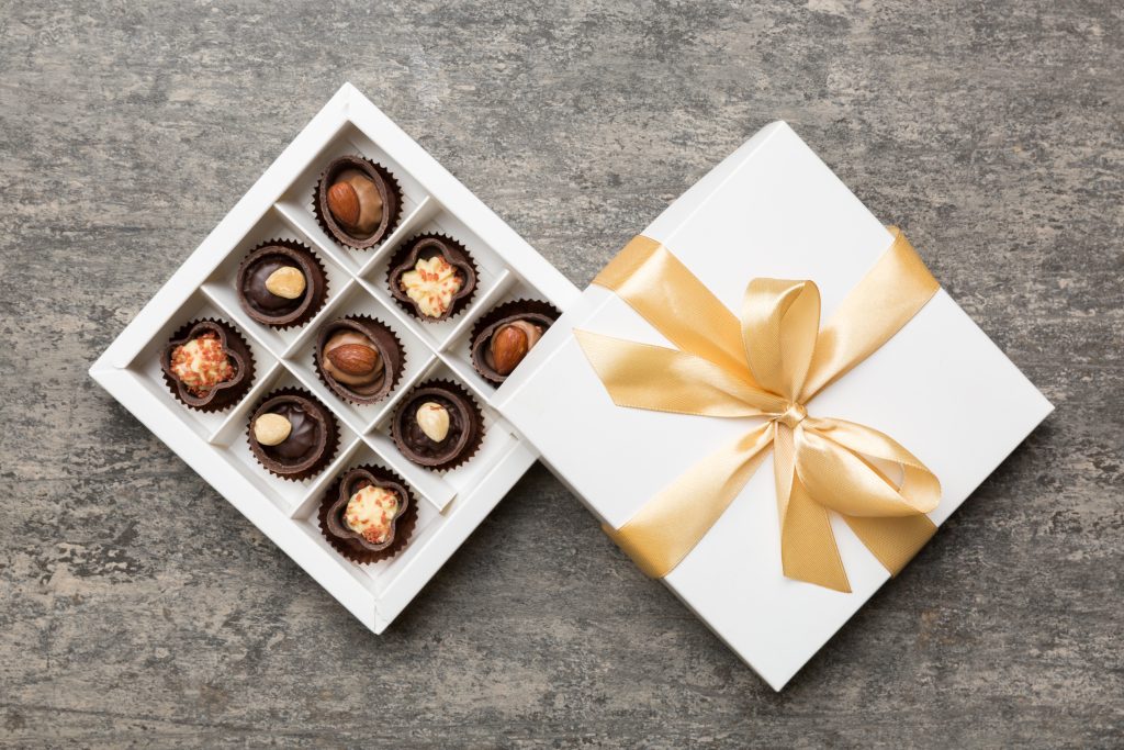 White box with chocolates candies and golden tape