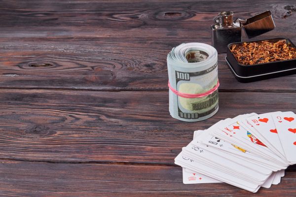 Cards and dollars for gambling. Top view tobacco with money